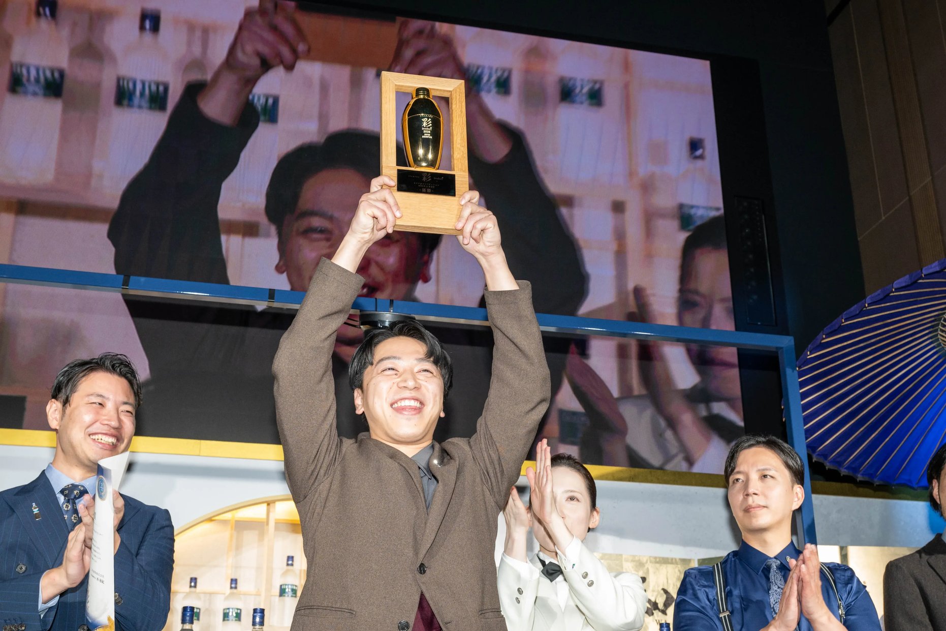 Yuya Takahashi, the inaugural Japan champion, raising the winner’s trophy high with both hands